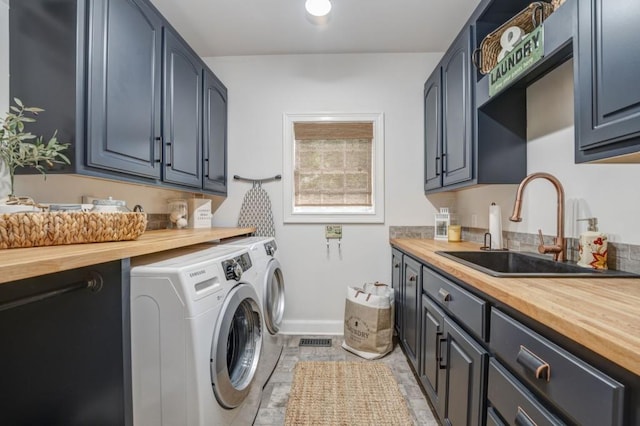 clothes washing area with cabinets, separate washer and dryer, and sink