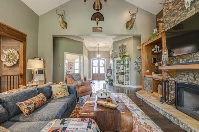 living room featuring ornate columns, a stone fireplace, dark wood-type flooring, and high vaulted ceiling