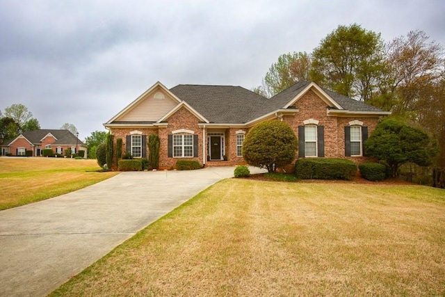 traditional home featuring brick siding, a front yard, and driveway