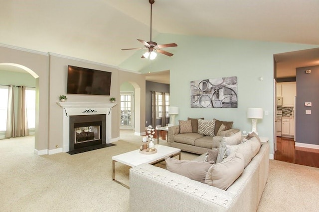living room with arched walkways, carpet, lofted ceiling, ceiling fan, and a multi sided fireplace