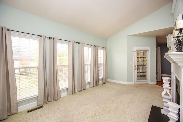 unfurnished living room featuring carpet floors, lofted ceiling, baseboards, and a fireplace