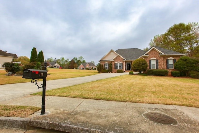 traditional home with a front lawn, concrete driveway, and brick siding