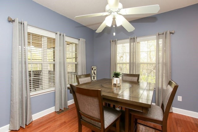 dining area with baseboards, a ceiling fan, and light wood-style flooring