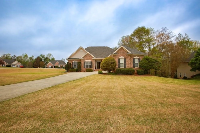traditional-style house with a front lawn, brick siding, and concrete driveway