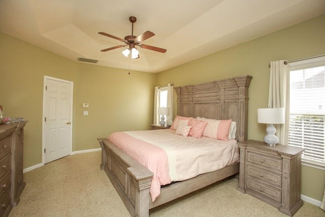 bedroom with multiple windows, light carpet, baseboards, and a ceiling fan