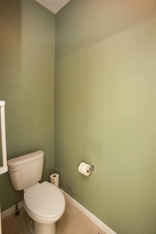 bathroom featuring tile patterned floors, toilet, and baseboards