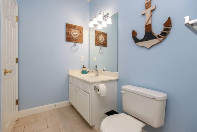 bathroom featuring toilet, tile patterned floors, vanity, and baseboards