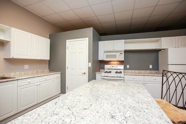kitchen with open shelves, white appliances, and white cabinets