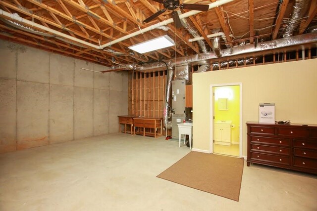unfinished basement with a ceiling fan and heating unit