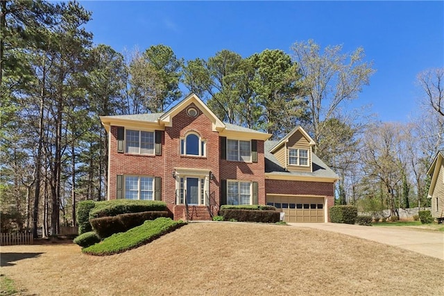 colonial inspired home featuring a garage, brick siding, and concrete driveway