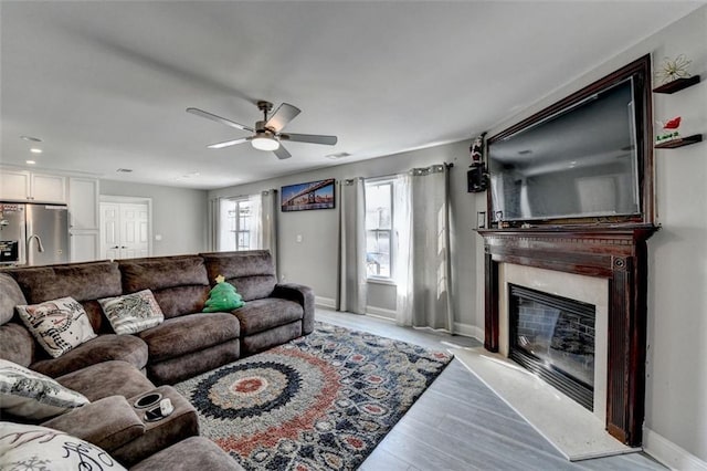 living room with light wood-type flooring and ceiling fan