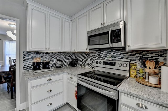 kitchen with backsplash, light stone countertops, white cabinets, and stainless steel appliances