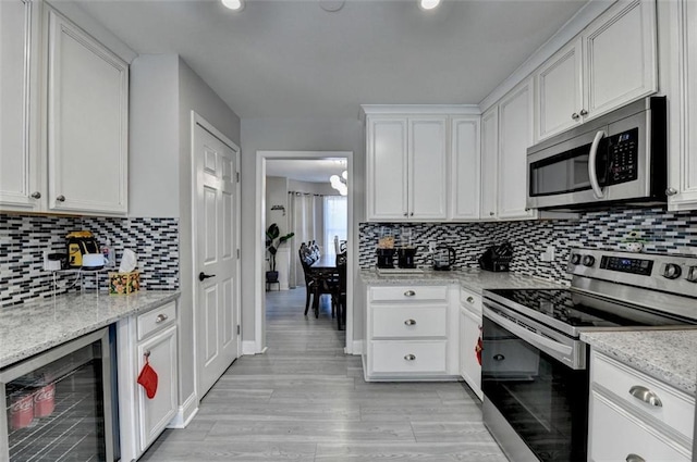 kitchen with white cabinets, stainless steel appliances, and wine cooler