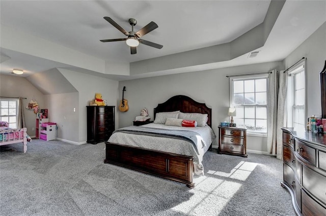 carpeted bedroom with a tray ceiling and ceiling fan