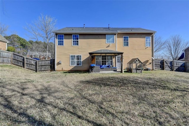 rear view of property featuring a gazebo, a lawn, and a patio