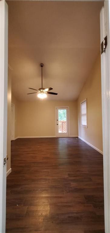 unfurnished room with dark wood-style floors, baseboards, ceiling fan, and vaulted ceiling