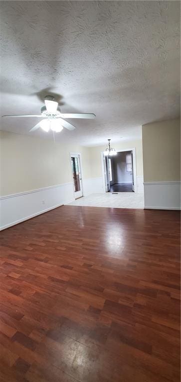 unfurnished living room featuring ceiling fan, a textured ceiling, and wood finished floors