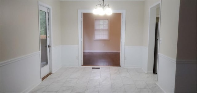 hallway featuring a wealth of natural light and visible vents