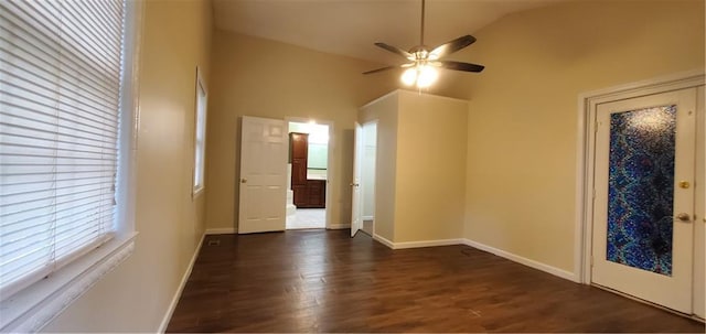 interior space with dark wood finished floors, vaulted ceiling, a ceiling fan, and baseboards