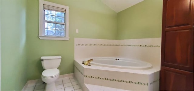 bathroom with a garden tub, baseboards, lofted ceiling, tile patterned floors, and toilet