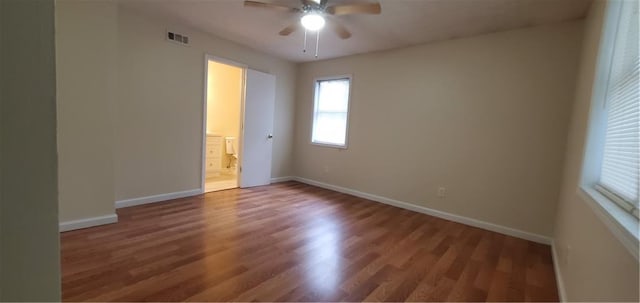 unfurnished room with visible vents, baseboards, ceiling fan, and wood finished floors