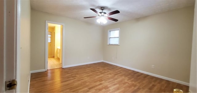 unfurnished bedroom featuring light wood-type flooring, baseboards, and ensuite bath