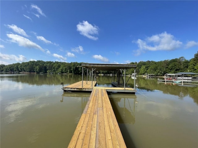 view of dock with a water view and a forest view