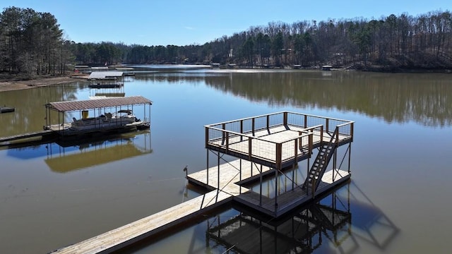 view of dock with a water view and a forest view