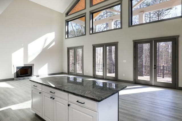 kitchen featuring plenty of natural light, white cabinetry, dark stone counters, and french doors