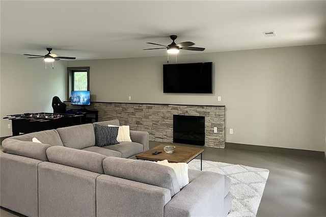 221 Dragonfly Cv, Toccoa, GA 30577 - living room featuring a ceiling fan, concrete floors, and a stone fireplace