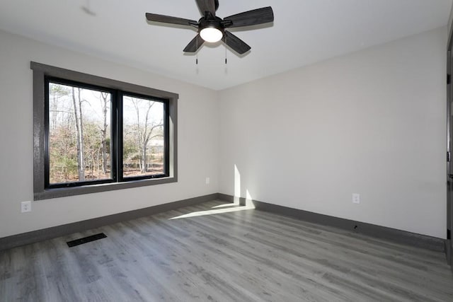 unfurnished room featuring ceiling fan and dark hardwood / wood-style floors