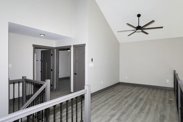 empty room with hardwood / wood-style floors, high vaulted ceiling, and ceiling fan