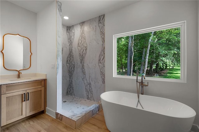 554 Mcdaniel Station Rd SW, Calhoun, GA 30701 - full bathroom with healthy amount of natural light, vanity, wood finished floors, a soaking tub, and recessed lighting