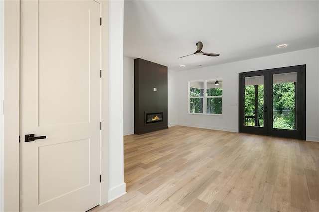 554 Mcdaniel Station Rd SW, Calhoun, GA 30701 - unfurnished living room featuring light wood-type flooring, a ceiling fan, baseboards, a large fireplace, and french doors