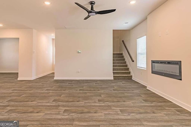 unfurnished living room featuring hardwood / wood-style flooring and ceiling fan