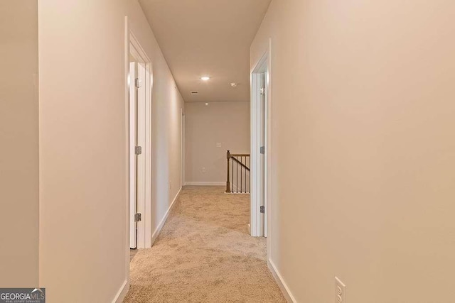 corridor featuring light colored carpet