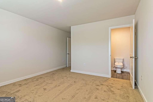 unfurnished bedroom featuring carpet flooring and ensuite bath