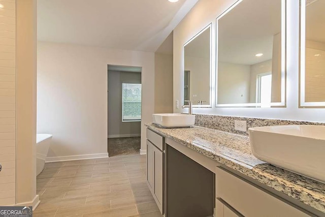 bathroom with hardwood / wood-style flooring, vanity, and a washtub