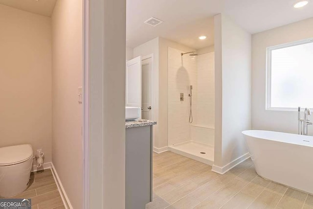 bathroom featuring shower with separate bathtub and toilet