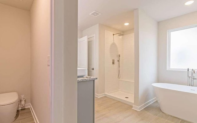 bathroom with hardwood / wood-style flooring, toilet, and separate shower and tub