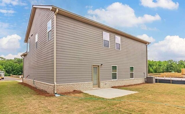 back of house with a patio and a lawn