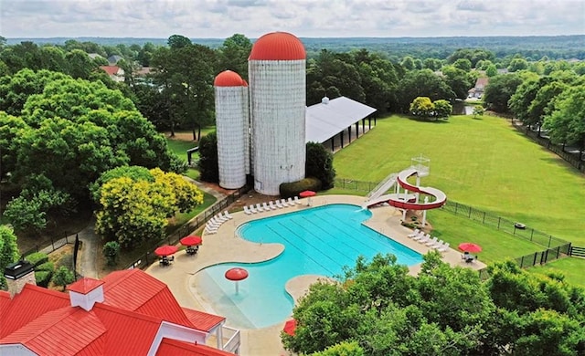 view of swimming pool featuring a patio area, a lawn, and a water slide