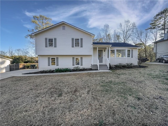 split level home with a front lawn and fence