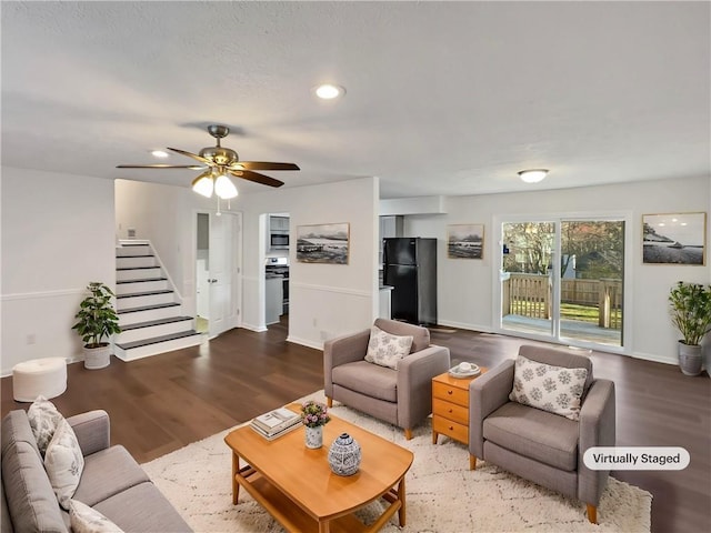 living area featuring stairway, baseboards, wood finished floors, and a ceiling fan