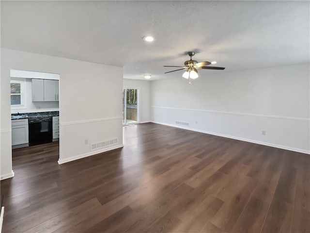 unfurnished living room with visible vents, baseboards, dark wood finished floors, and a ceiling fan