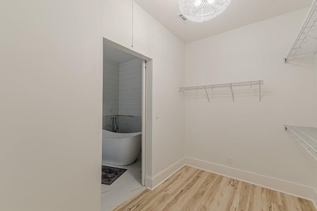 379 Bohannon Rd, Grantville, GA 30220 - walk in closet featuring light wood-type flooring and a chandelier