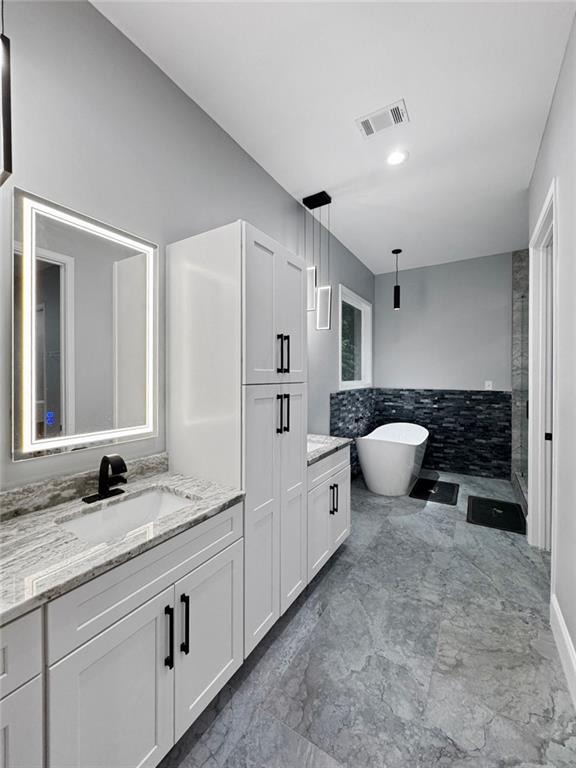 244 Coastline Rd, Fayetteville, GA 30214 - bathroom featuring vanity, a soaking tub, marble finish floors, walk in shower, and tile walls