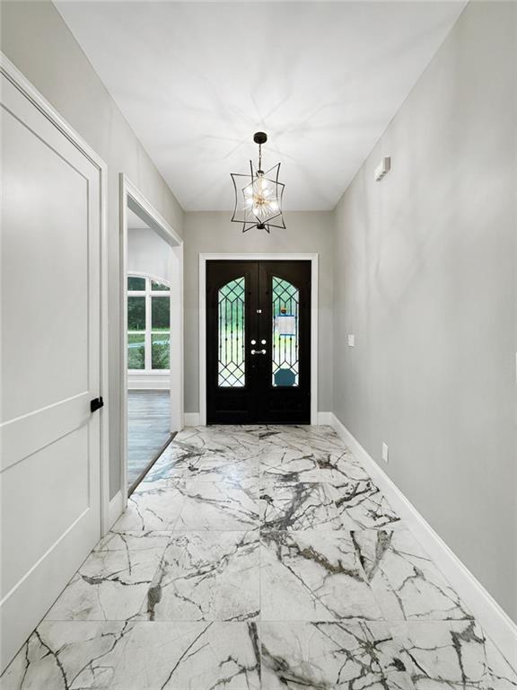 244 Coastline Rd, Fayetteville, GA 30214 - entryway with marble finish floors, a chandelier, baseboards, and french doors