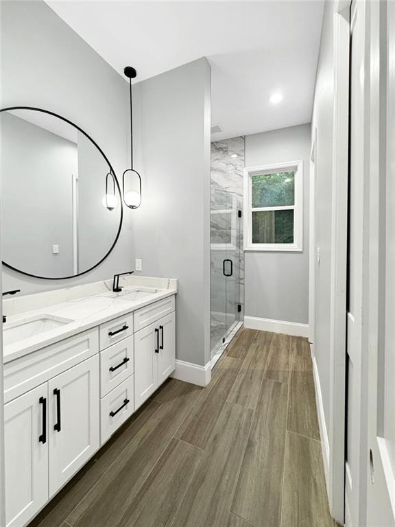 244 Coastline Rd, Fayetteville, GA 30214 - bathroom with a shower stall, double vanity, wood finished floors, and baseboards