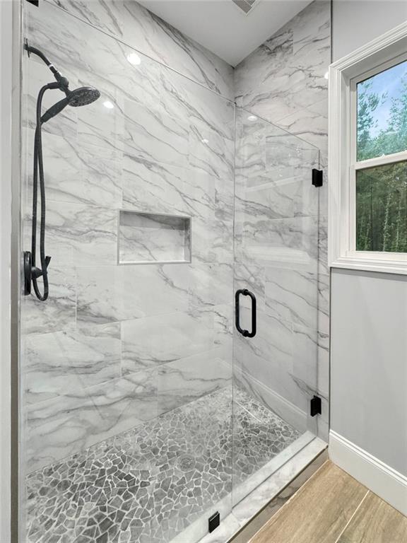 244 Coastline Rd, Fayetteville, GA 30214 - full bath with a marble finish shower, wood finished floors, and baseboards